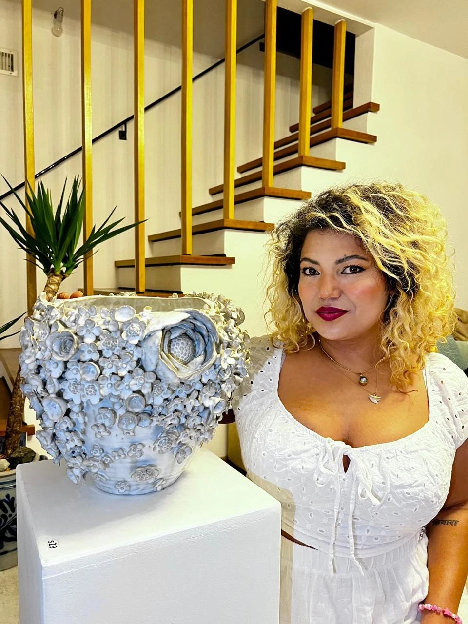 Shristi Shrestha Demougeot beside her floral ceramic vessel