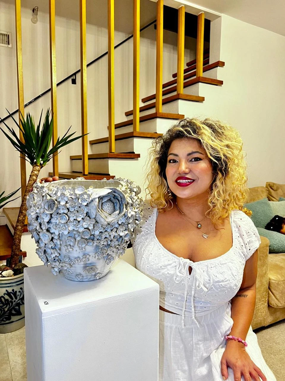 Shristi Shrestha Demougeot beside her floral ceramic sculpture